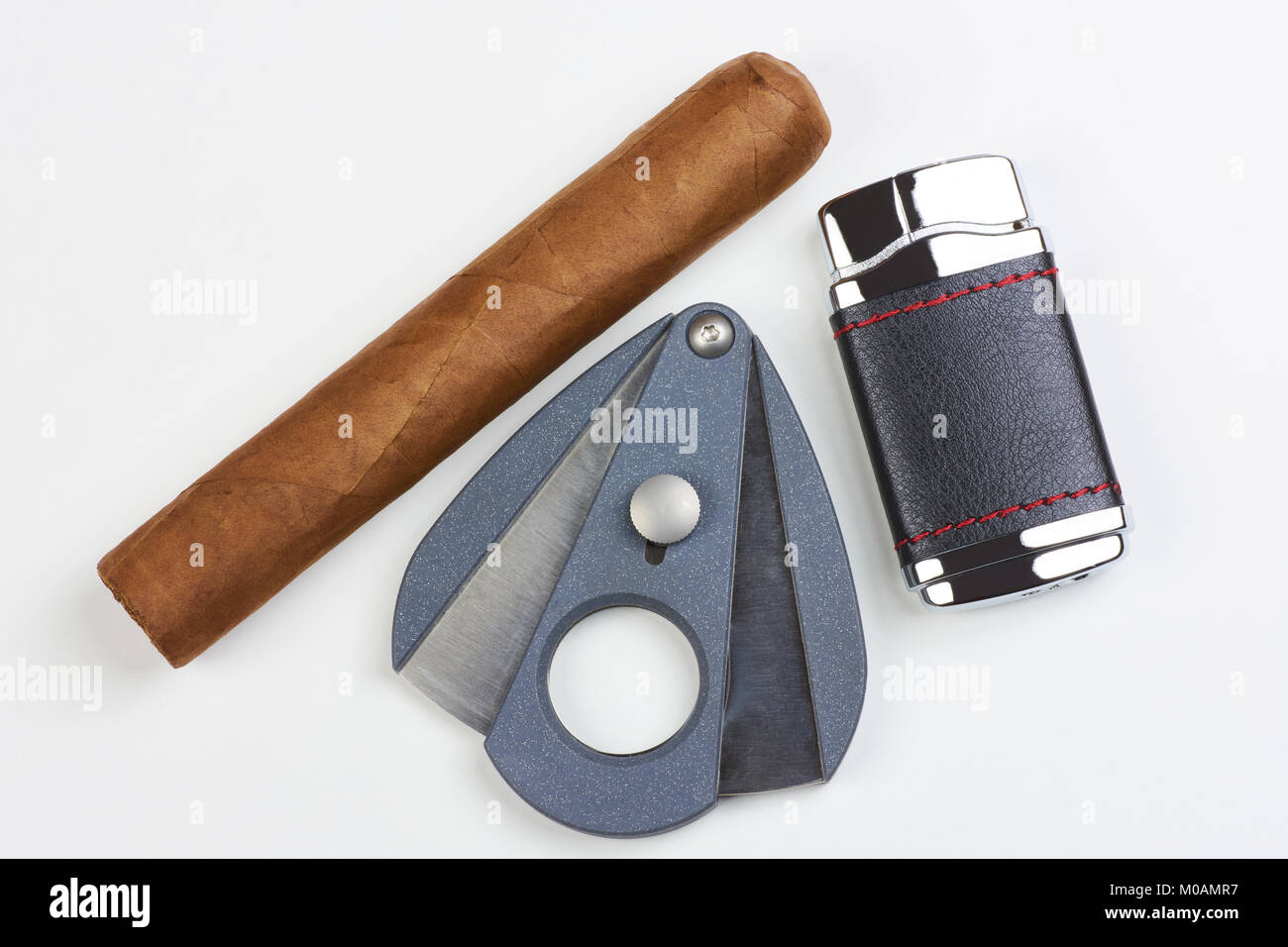 Cigare cubain avec un briquet et un couteau sur un fond blanc Banque D'Images