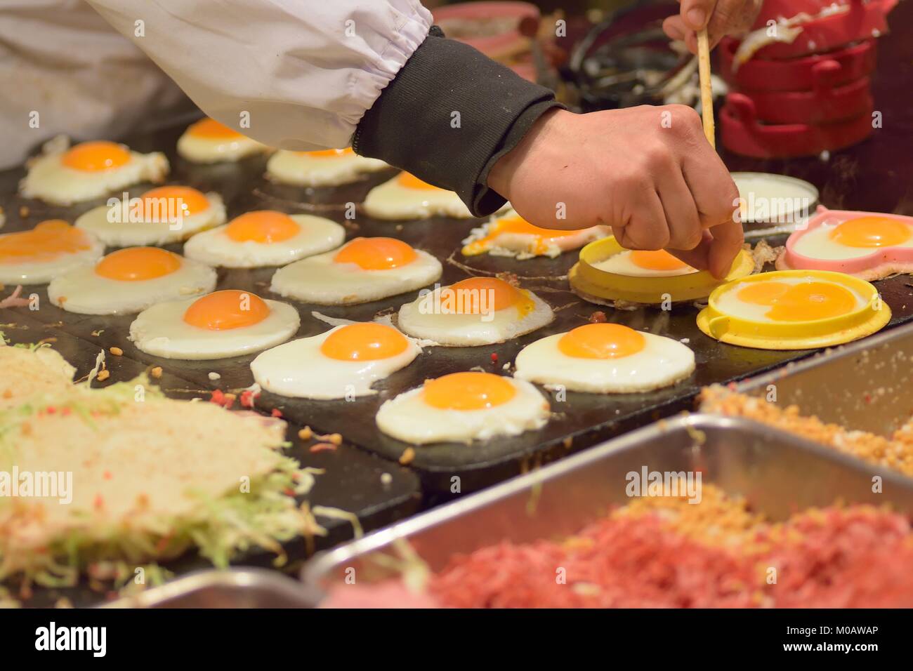 L'alimentation de rue japonais célèbre appelé Okonomiyaki en préparation à des stands de nourriture à Tokyo Banque D'Images