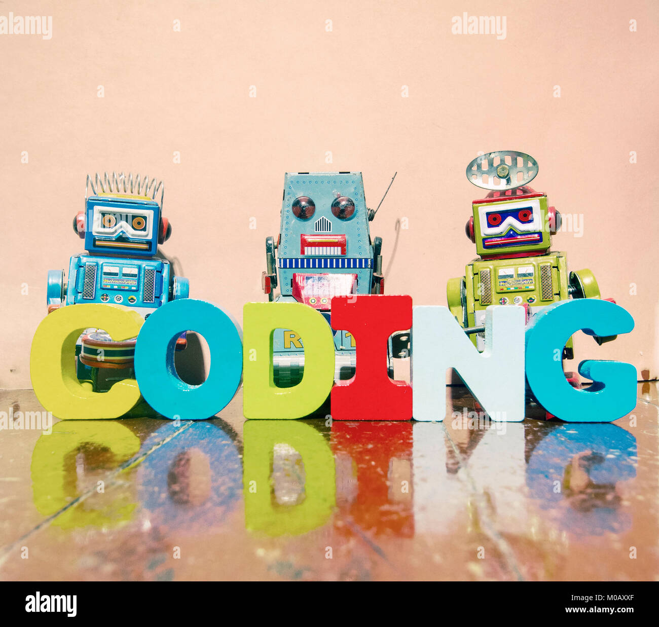 Le mot d'esprit de codage des lettres en bois sur un vieux plancher en bois avec des jouets robot retro Banque D'Images