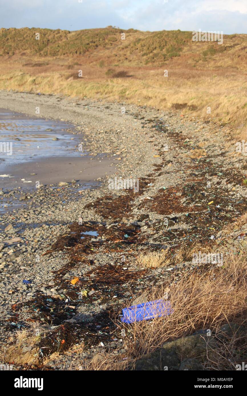 Plage à Port Logan couvert de litière en plastique Banque D'Images