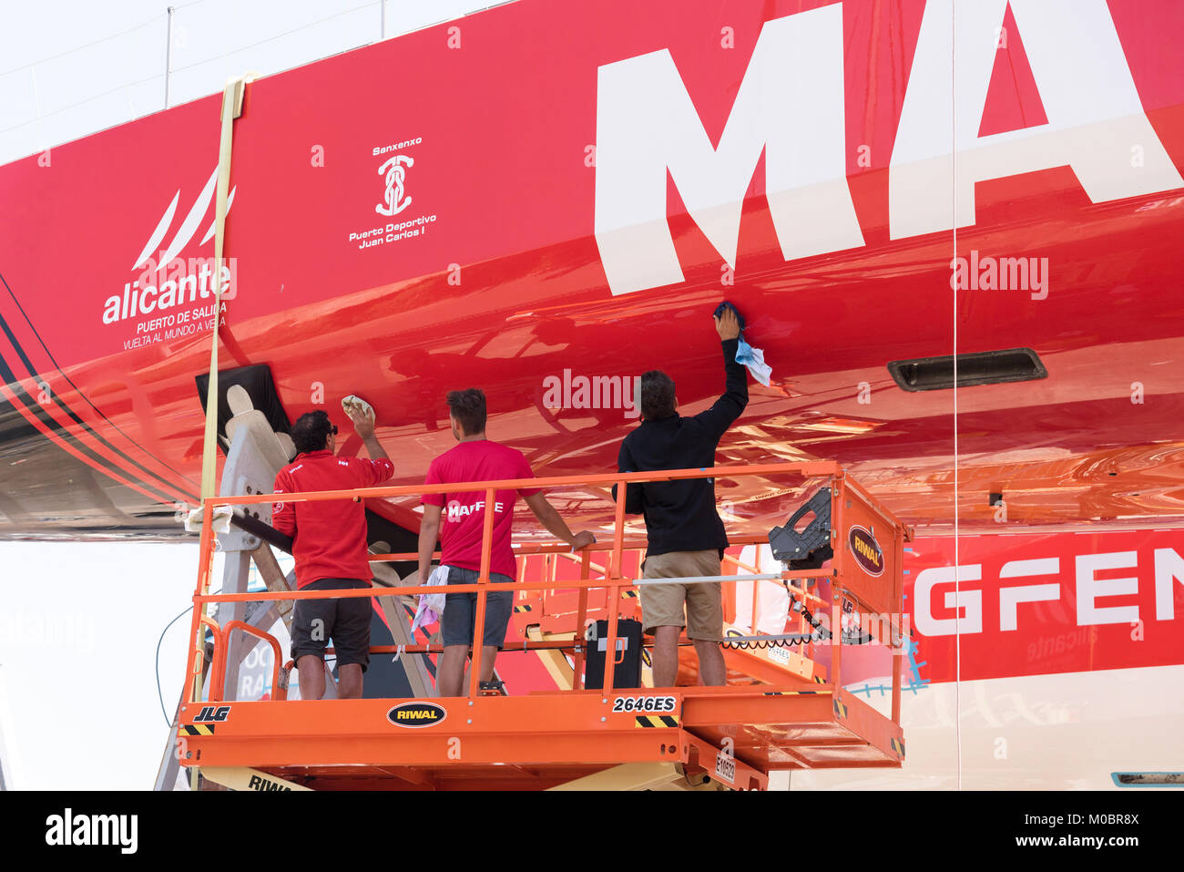 Front de mer du Cap Afrique du Sud. Décembre 2017. La Volvo Ocean Race. Bateau de course Mapfre. La coque de polissage par trois membres de l'équipe à l'aide de ciseaux Banque D'Images