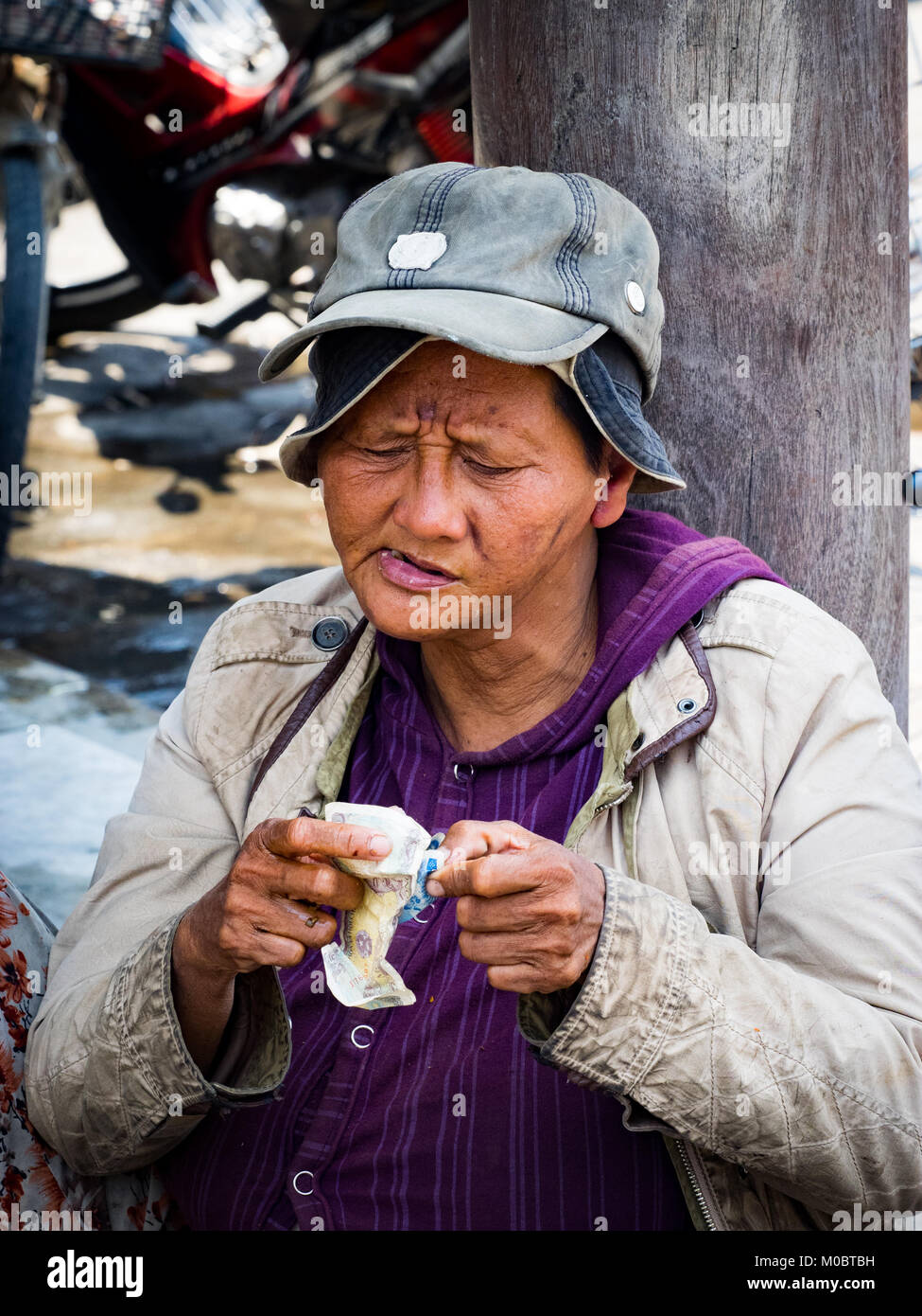 Malades Mentaux dame mendier dans les rues de Hoi An. Banque D'Images
