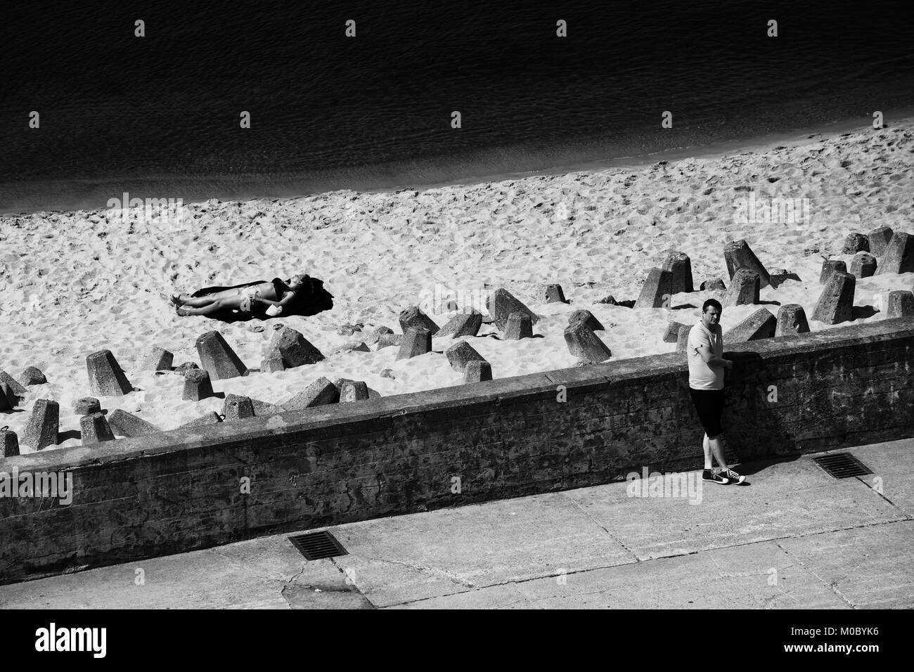 Le noir et blanc de l'hôtel town waterfront sur la mer Baltique, brise-lames en béton renforcé avec plage de sable, des blocs de lignes diagonales contrastées Banque D'Images
