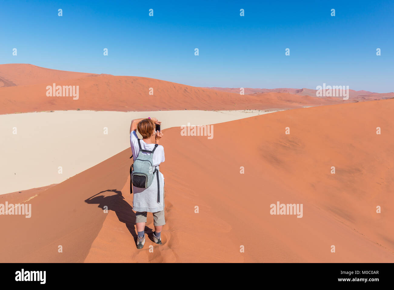 Photo prise touristiques à Sossusvlei, Namibie. Des dunes de sable, désert du Namib, le Namib Naukluft National Park, voyage aventure en Afrique. Banque D'Images