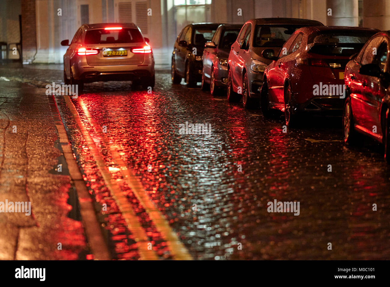 Location de freinage sur rue pavée humide nuit à Belfast en Irlande du Nord uk Banque D'Images