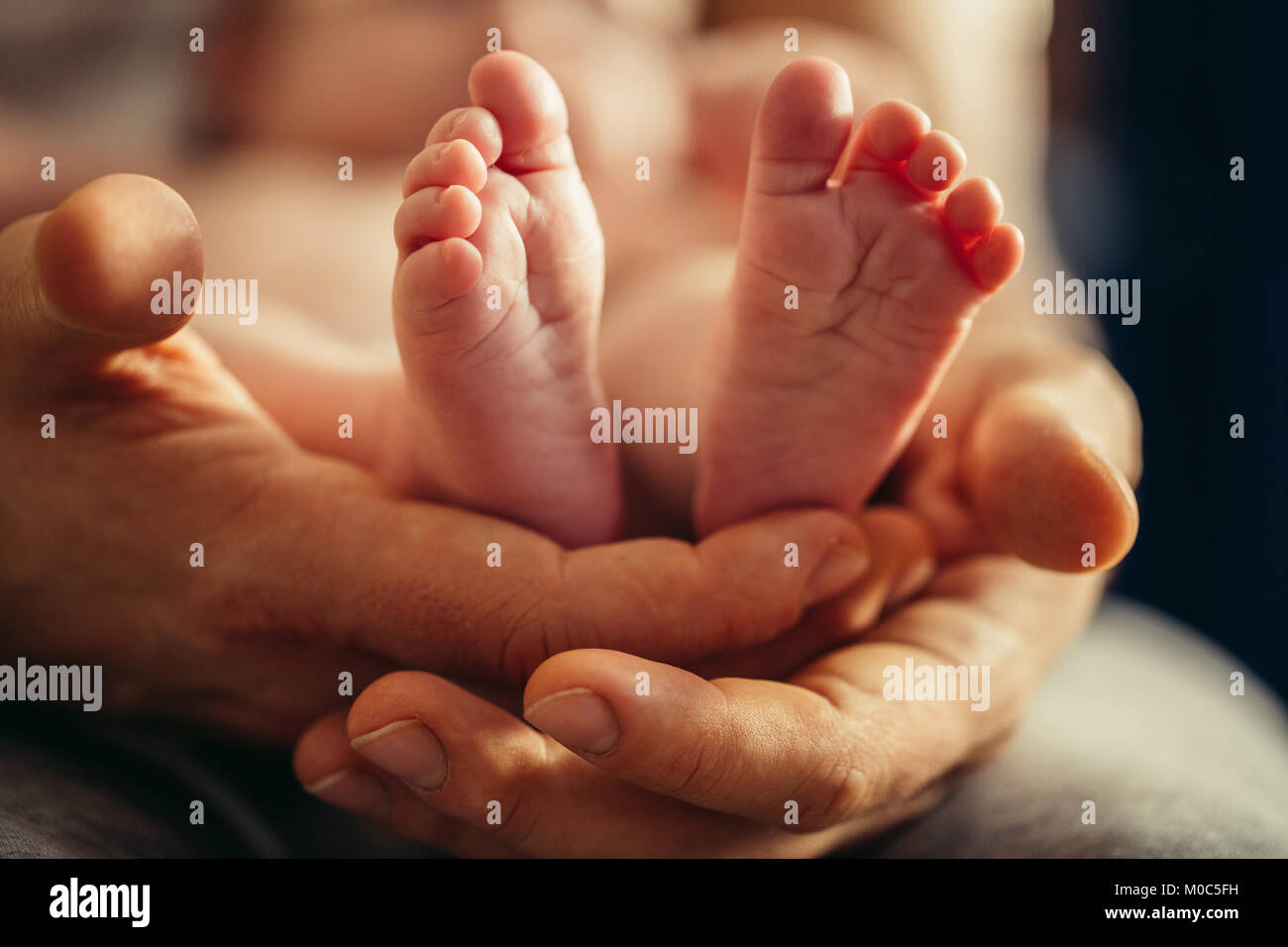 Bébé nouveau-né dans les jambes de Belles Mères part avec soft focus sur le pied d'babie Banque D'Images