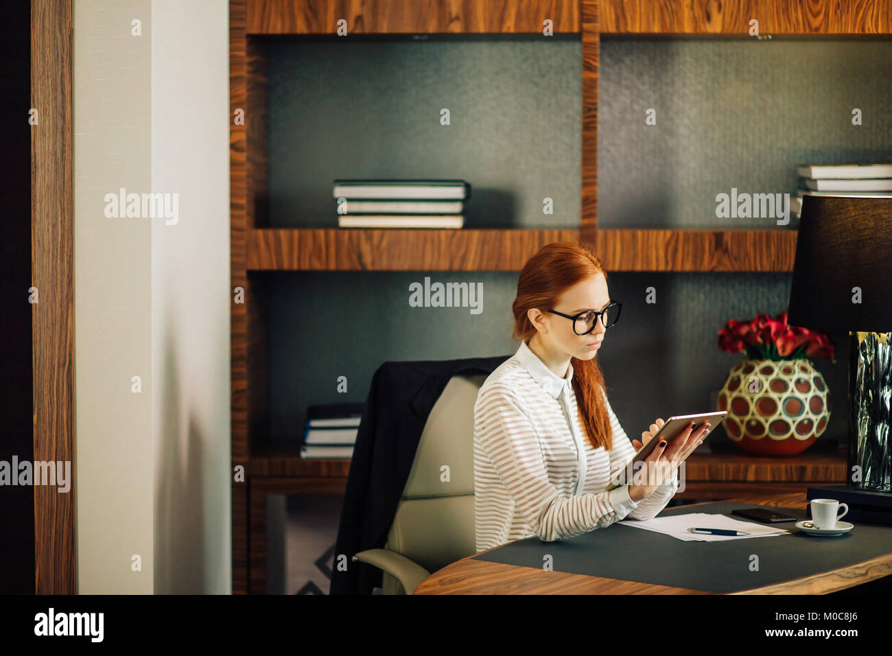 Businesswoman wearing glasses using digital tablet in office Banque D'Images