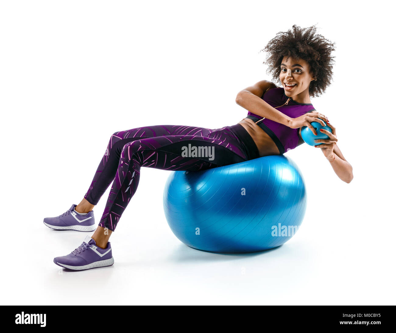 Smiling fille sportive remise en forme faire exerrcise sur ballon de