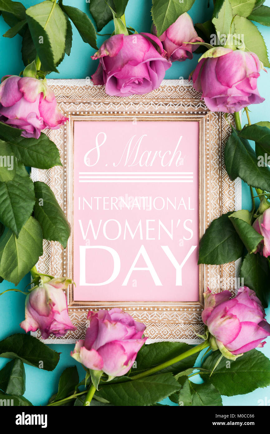 Bonne Journée de la femme télévision jeter l'arrière-plan. Beau cadre photo vintage en bois avec Happy Womens Day tiens et des roses roses. Banque D'Images