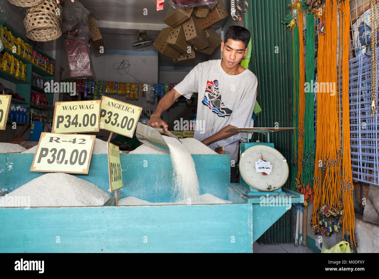 Vendeur de riz philippin bacs remplit son marché public de Barretto Ville, l'île de Luzon, aux Philippines. Banque D'Images