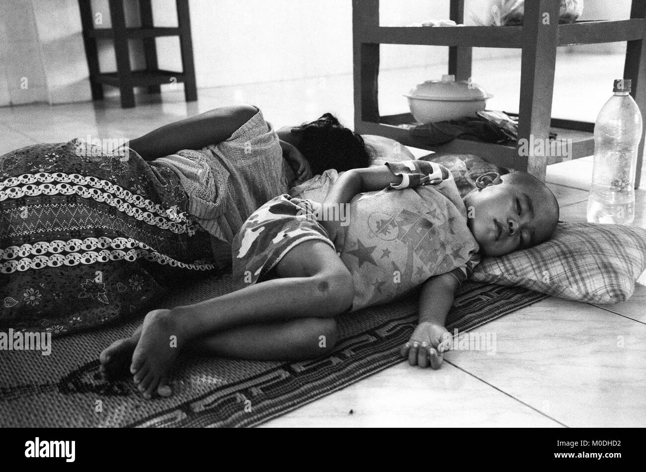 Un jeune garçon se trouve gravement malades dans le service de pédiatrie à la clinique Mae Tao sur la frontière thaïlando-birmane. Environ 300 personnes par jour reçoivent des soins gratuits à la clinique, la plupart étant des travailleurs migrants et réfugiés qui ont franchi la frontière de la Birmanie (Myanmar) pour échapper à la pauvreté désespérée et la persécution du régime militaire. Les soins de santé sont tous mais inexistante en Birmanie, où moins de 2  % du PIB est consacré à la santé et l'éducation combinées. Banque D'Images