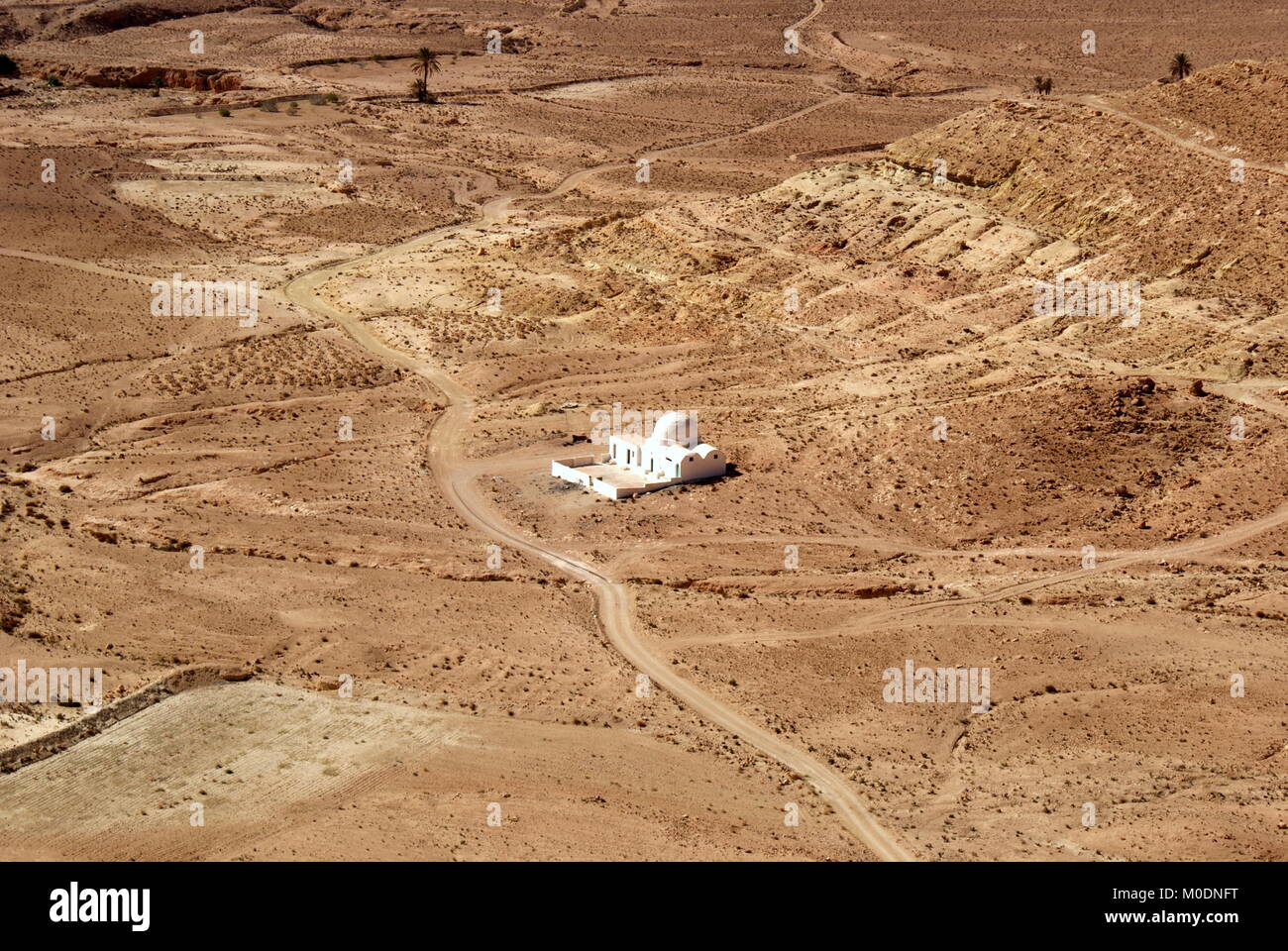 Vue depuis la colline abandonnée village berbère de Douiret d'une seule mosquée Blanche et le paysage aride environnant, district de Tataouine, Tunisie Banque D'Images