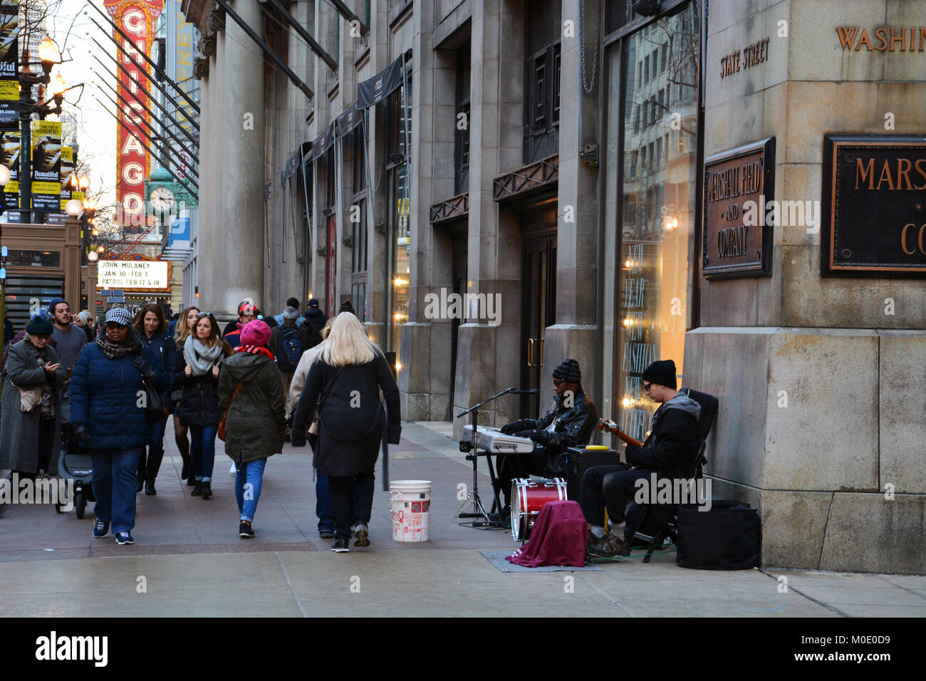 Blues des musiciens de rue de profiter d'un week-end d'hiver chaud et ensoleillé à confiture sur le trottoir de la rue de l'État pour les touristes au centre-ville de Chicago. Banque D'Images