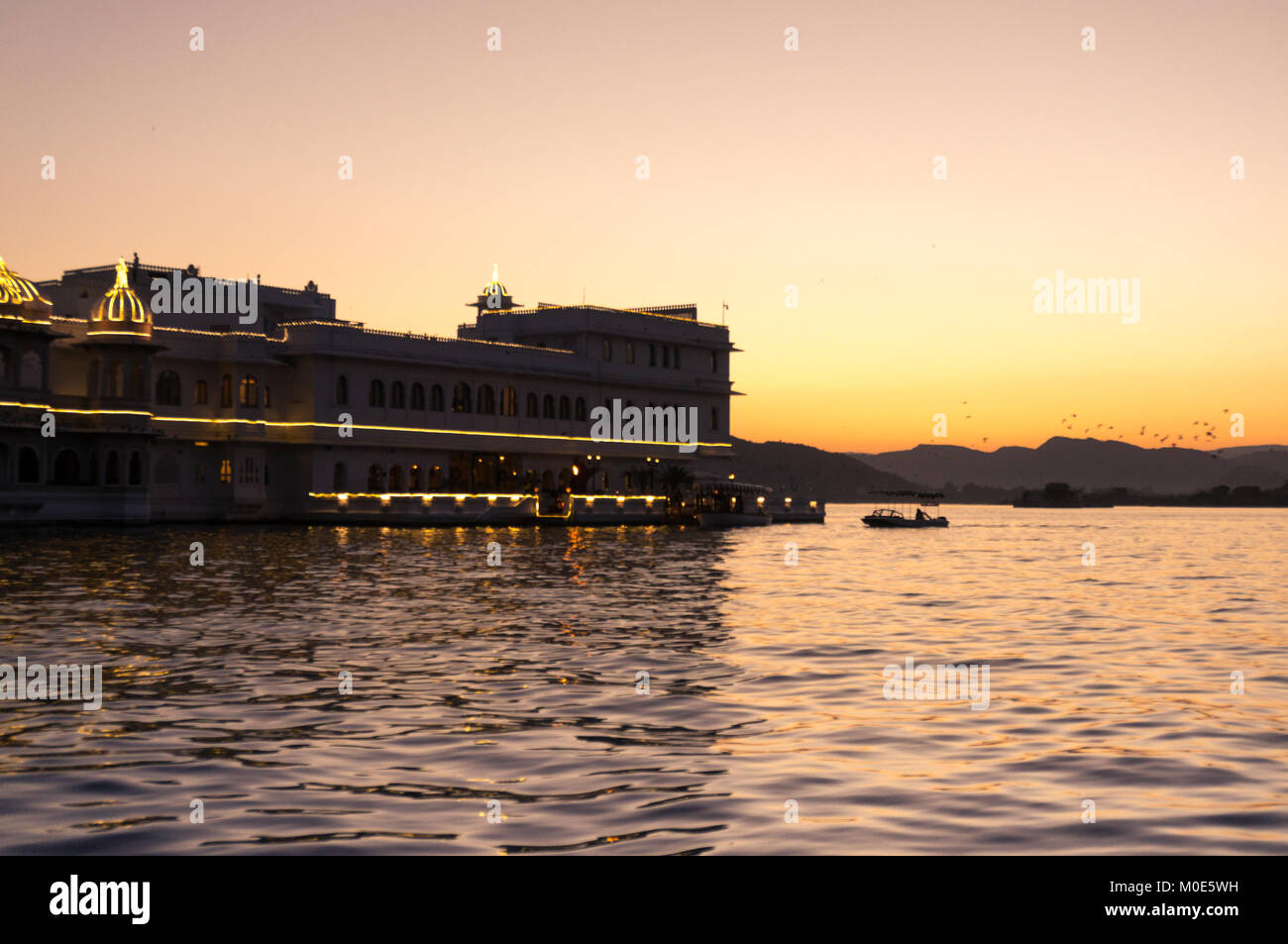 Jag nivas lake palace sur le lac Pichola au crépuscule. Cet hôtel de luxe se trouve sur une île artificielle au milieu du lac. C'est un endroit populaire pour les touristes de séjour Udaipur Rajasthan Inde Banque D'Images