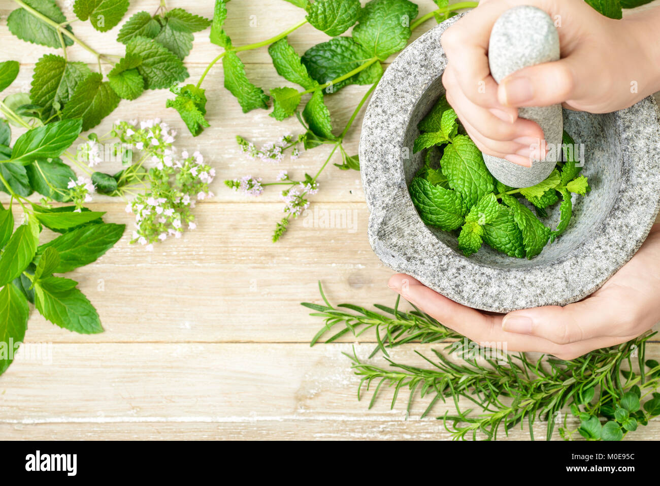 Des herbes fraîches et mortier de pierre sur la planche de bois, vue du dessus Banque D'Images