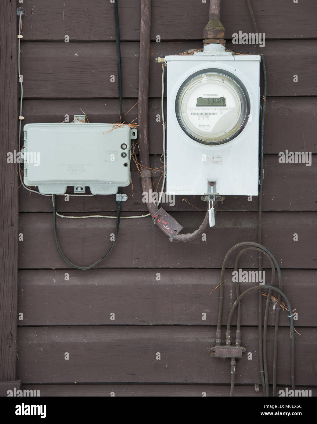 Un compteur électrique, téléphone fort et de la télévision par câble connexions d'utilité à l'extérieur d'une maison de spéculateur, NY USAcables. Banque D'Images