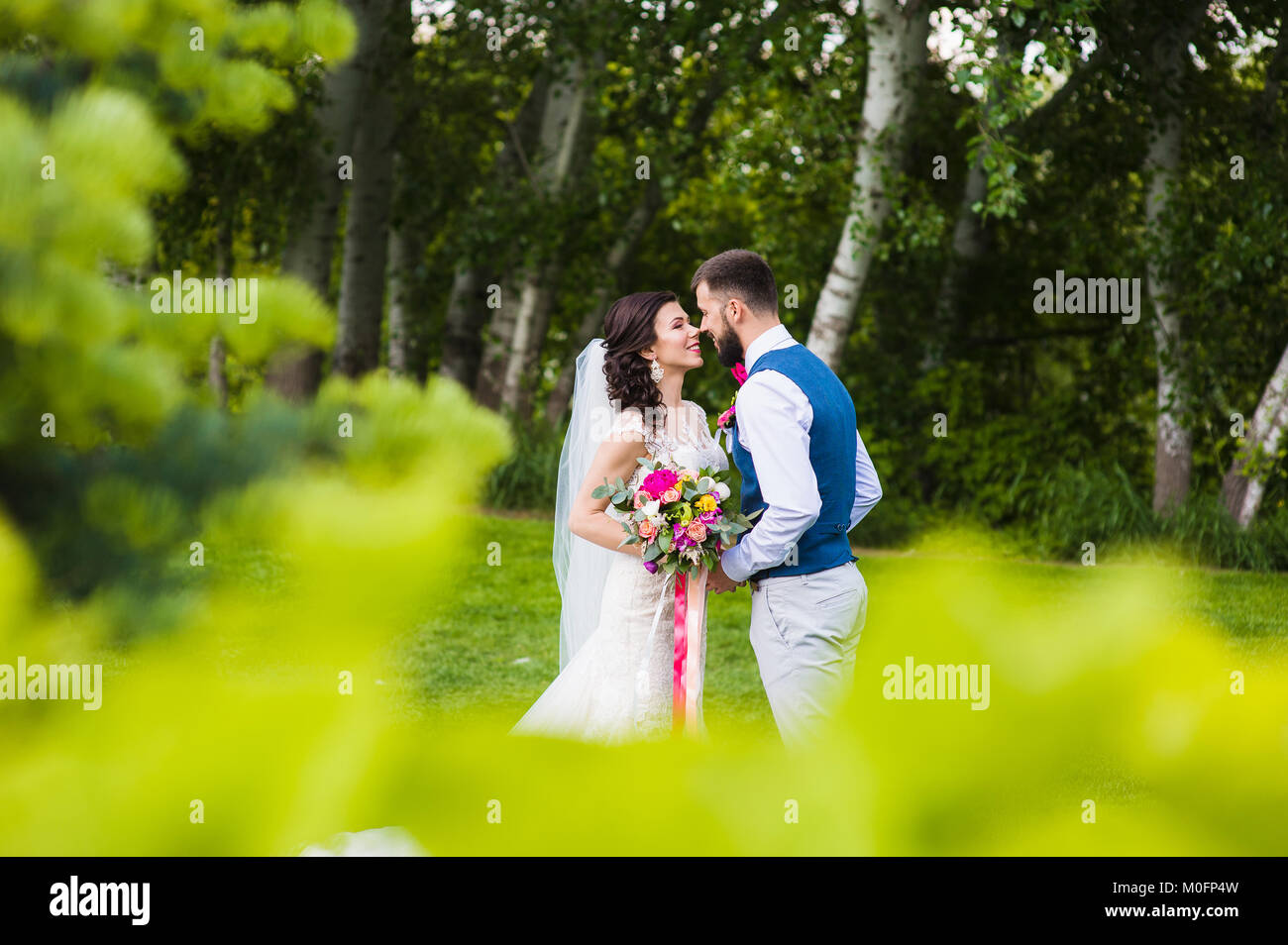 Sweet mariage couple in love va baiser dans la nature verdoyante d'arrière-plan de campagne Banque D'Images
