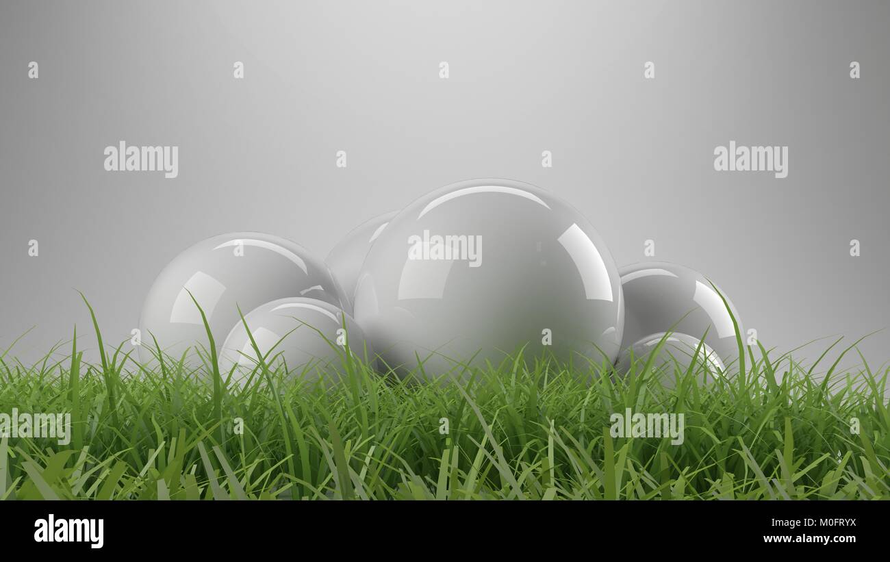 Le rendu 3D de sphères réfléchissantes avec l'herbe au premier plan Banque D'Images
