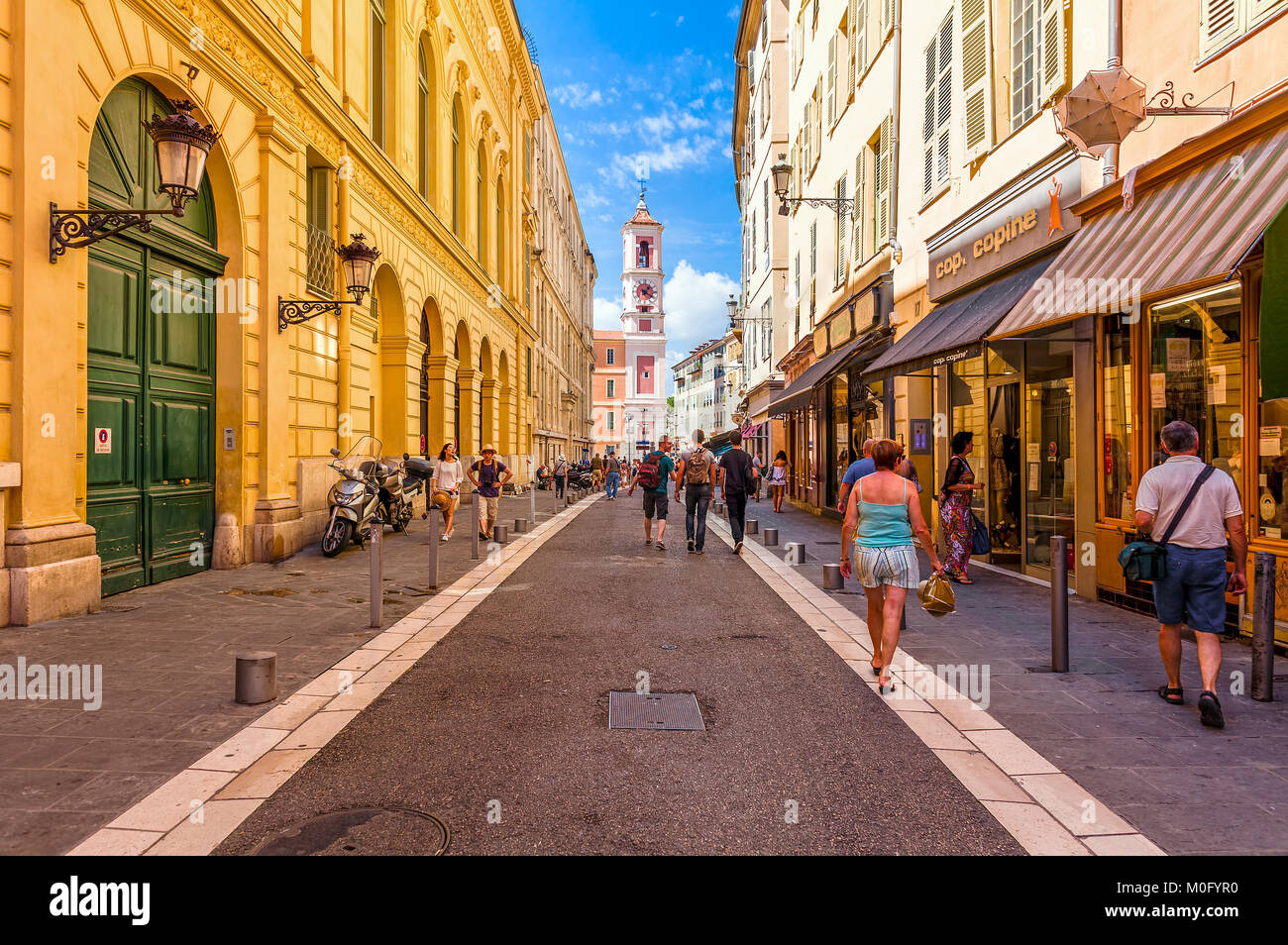 Les gens qui marchent sur la rue étroite dans la vieille partie touristique de Nice. Banque D'Images