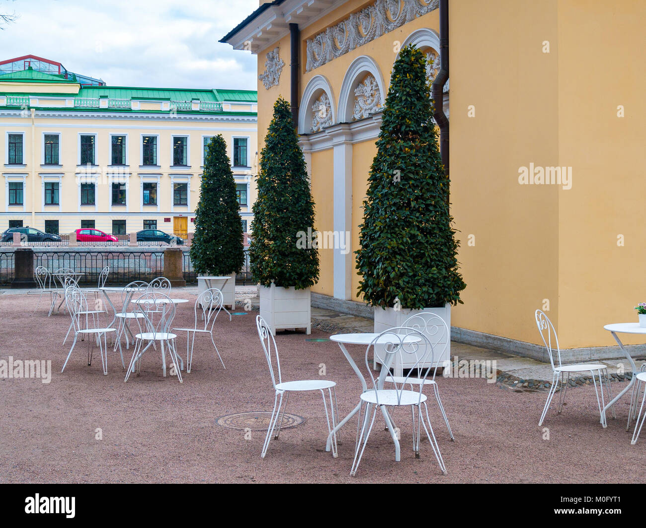 Cafe dans le parc en plein air au début du printemps en avril contre l'arrière-plan des bâtiments avec des chaises et ajouré blanc tableaux blancs avec un l Banque D'Images