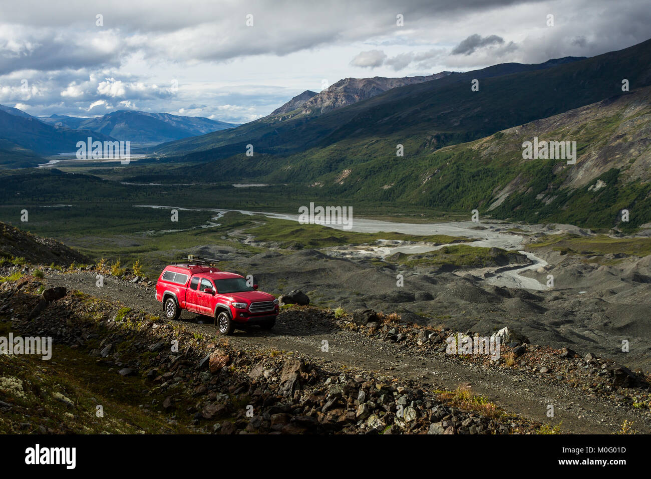 Un camion rouge le long d'une route à quatre roues motrices dans le Delta, montagnes de l'Alaska. La route se situe très au-dessus du glacier Canwell, couverts de morai Banque D'Images