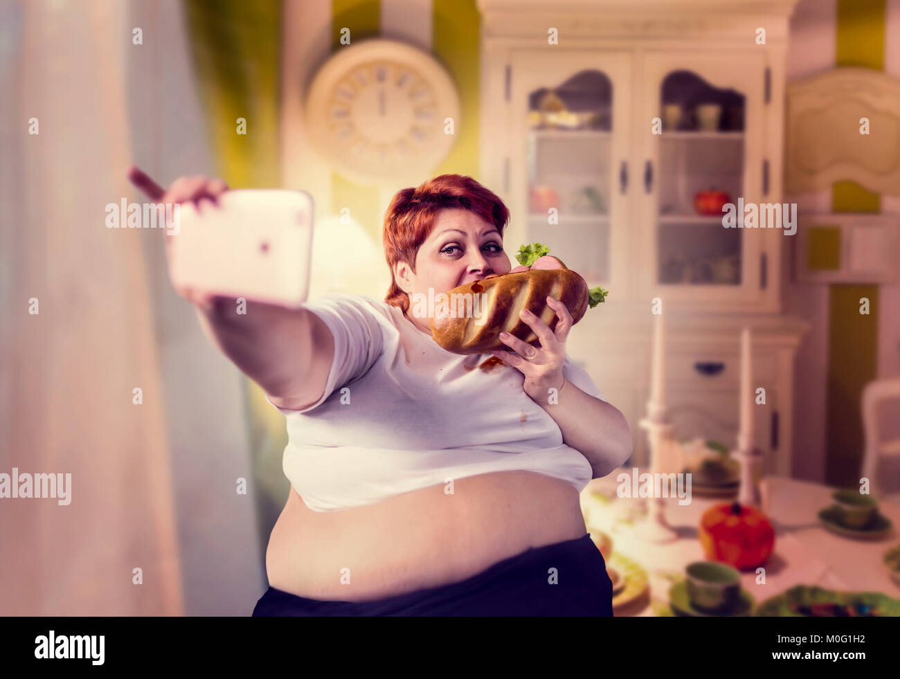 Grosse femme mange des sandwichs et des selfies permet, de l'obésité, les gens. Mode de vie malsain, femelle gras Banque D'Images