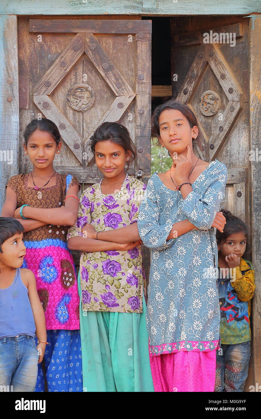 BUNDI, Rajasthan, INDE - Le 09 décembre 2017 : Portrait de trois jeunes filles et deux enfants se tenant à l'entrée d'une maison dans un village proche de Banque D'Images