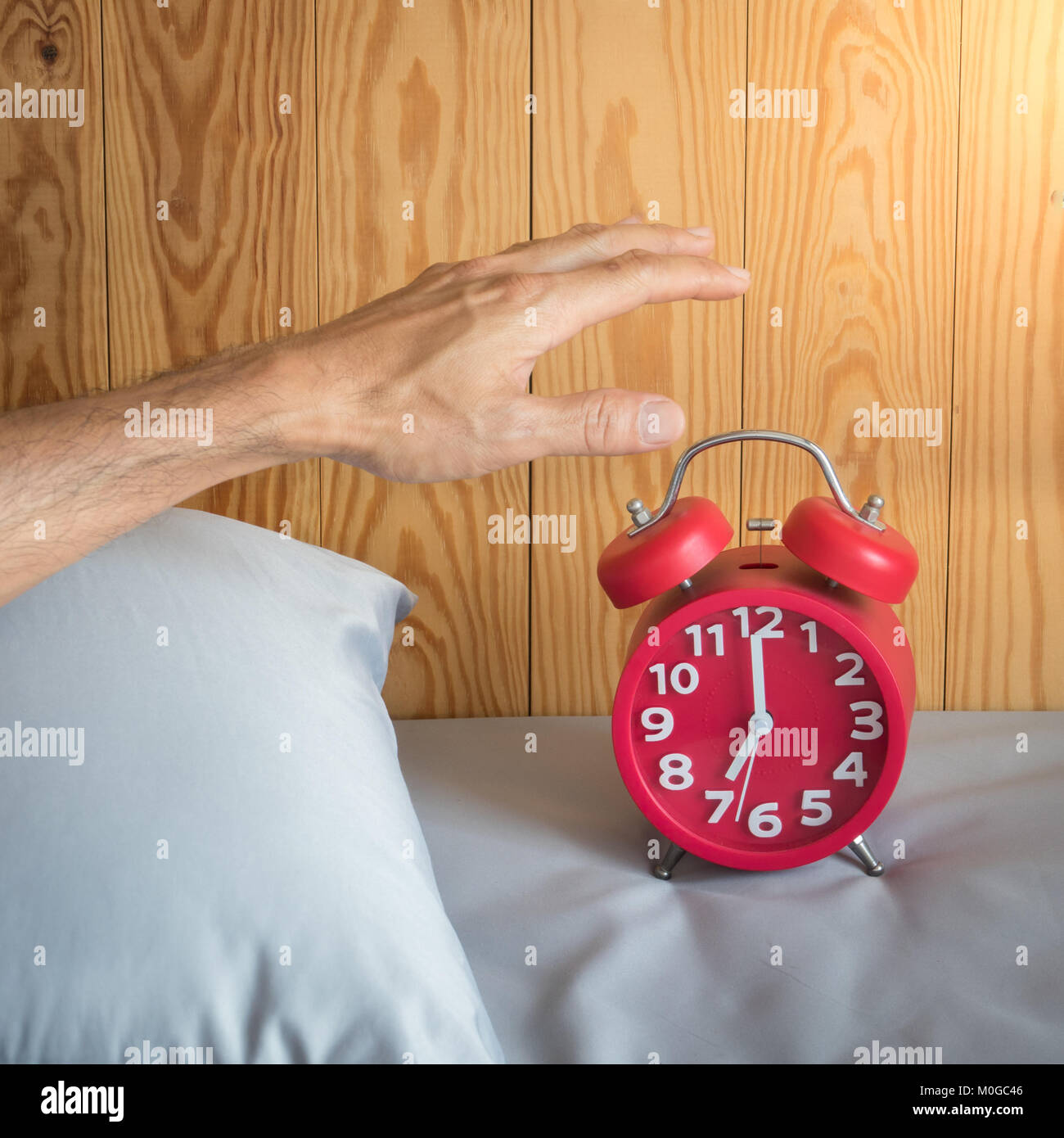 Main d'un homme désactiver le réveil au matin Photo Stock - Alamy