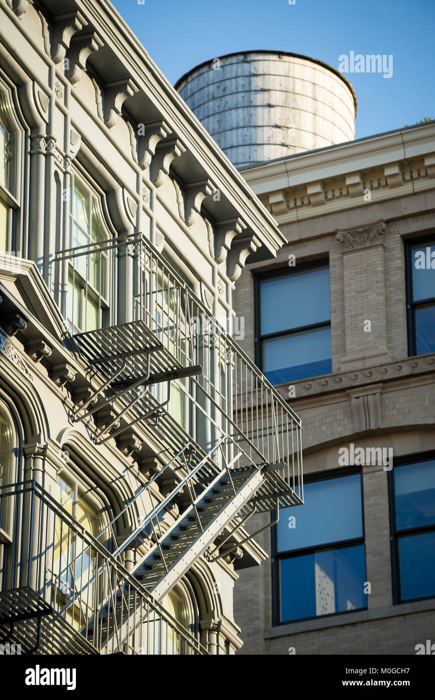 Vue détaillée de l'architecture traditionnelle de l'escalier de secours et château d'eau en bois dans le quartier historique de fer de fonte de SoHo au centre-ville de Manhattan, New York Banque D'Images