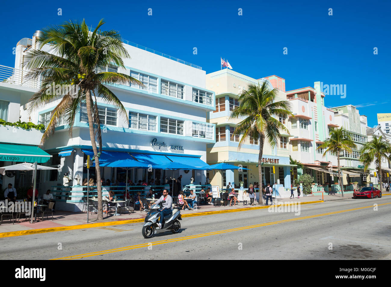 MIAMI - 29 décembre 2017 : Un scooter passe l'emblématique de l'architecture Art Déco de Ocean Drive sur un matin étonnamment désert. Banque D'Images
