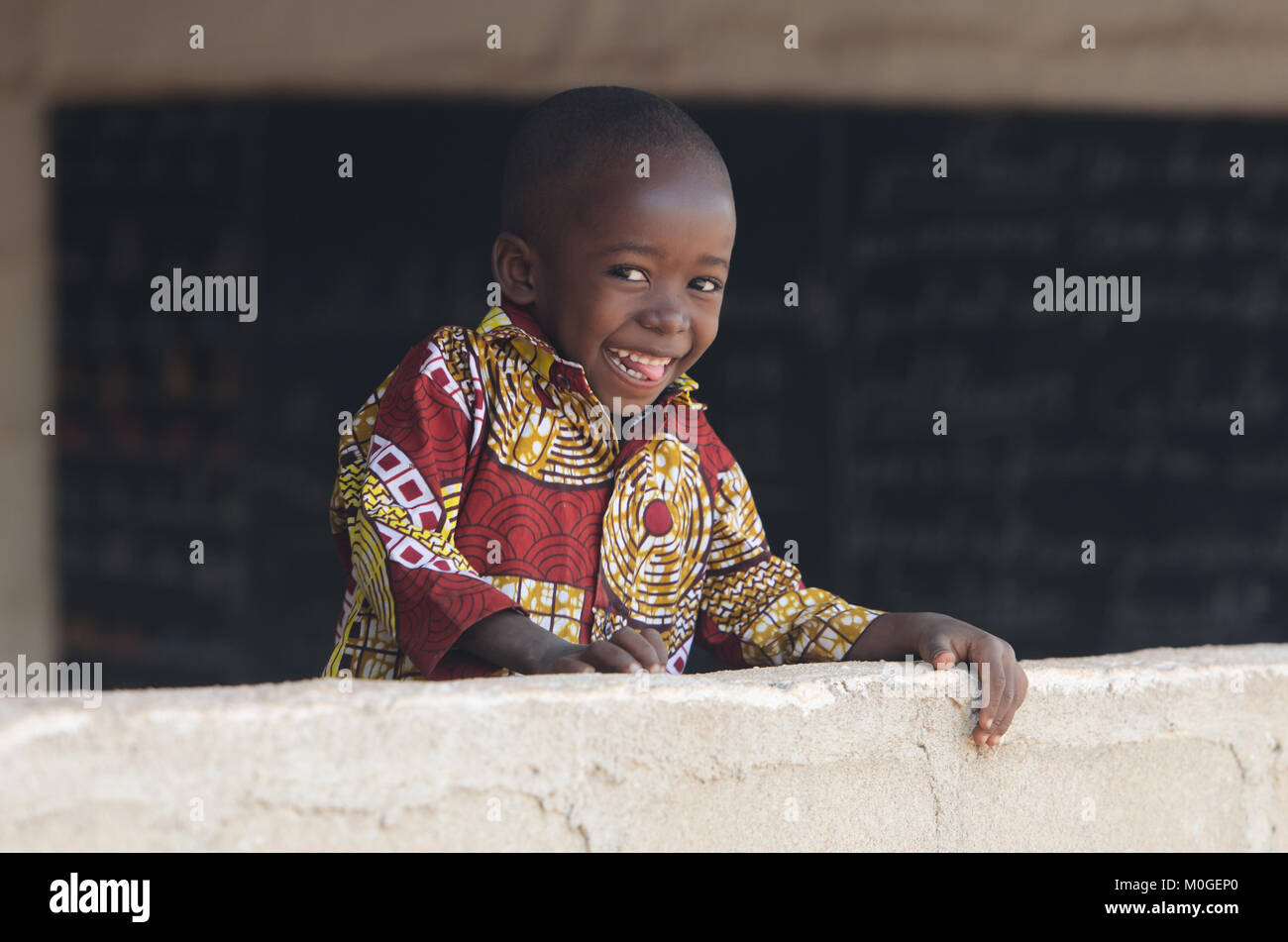 Superbe enfant sourit à l'École de l'Afrique de l'arrière-plan Banque D'Images