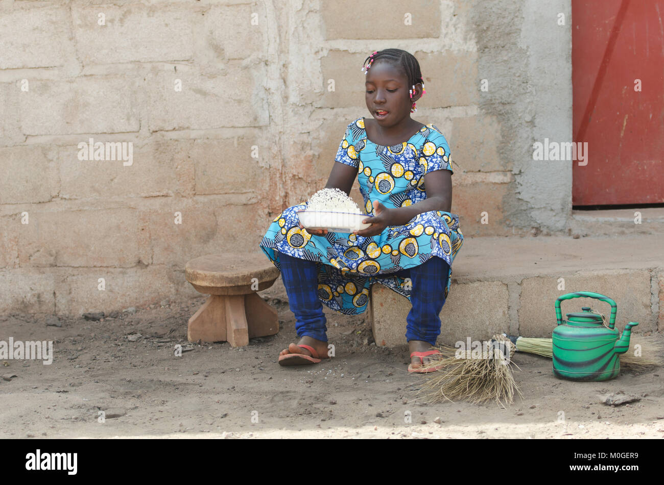 Shot candide fille noire africaine de la cuisson du riz à l'extérieur Banque D'Images