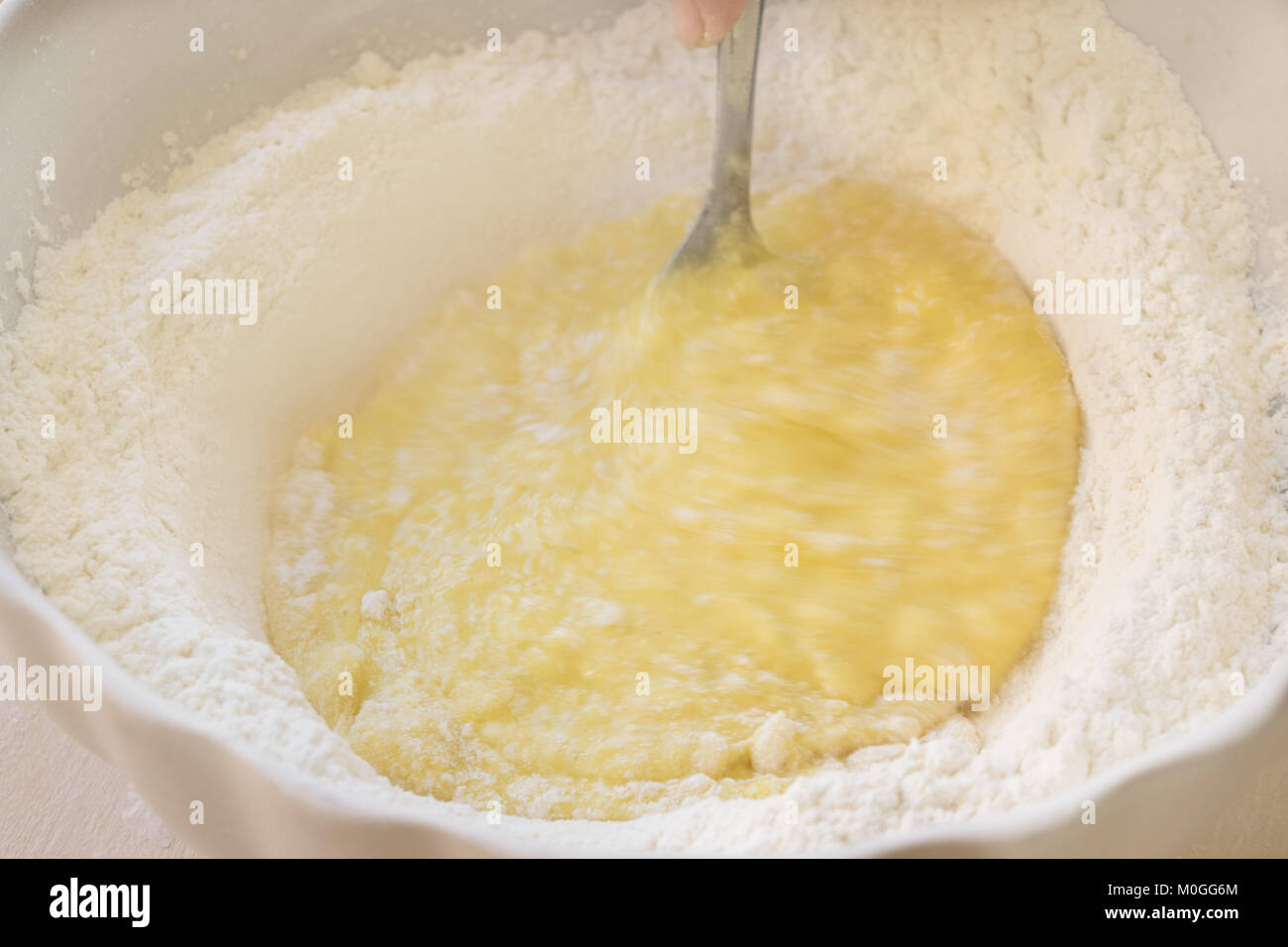 Les oeufs battus et la farine pour préparer une pâte à gâteau Banque D'Images