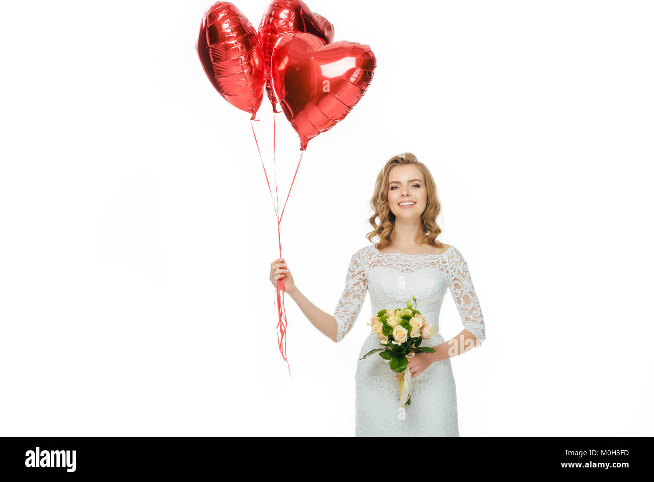 Belle Mariée en robe de mariage avec des ballons en forme de coeur et mariage bouquet isolated on white Banque D'Images