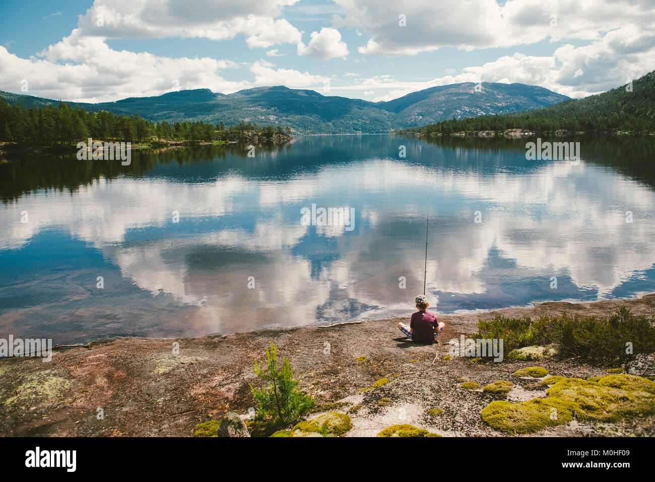 Un paysage en Norvège avec un lac, nuage réflexions, garçon de pêche. Banque D'Images
