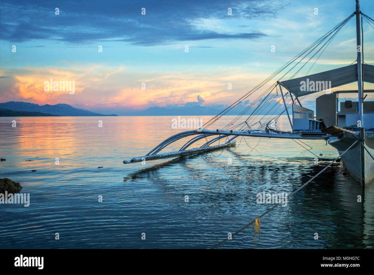 Banka, bateau de pêche traditionnelle des Philippines au coucher du soleil, l'île de Cebu, aux Philippines Banque D'Images