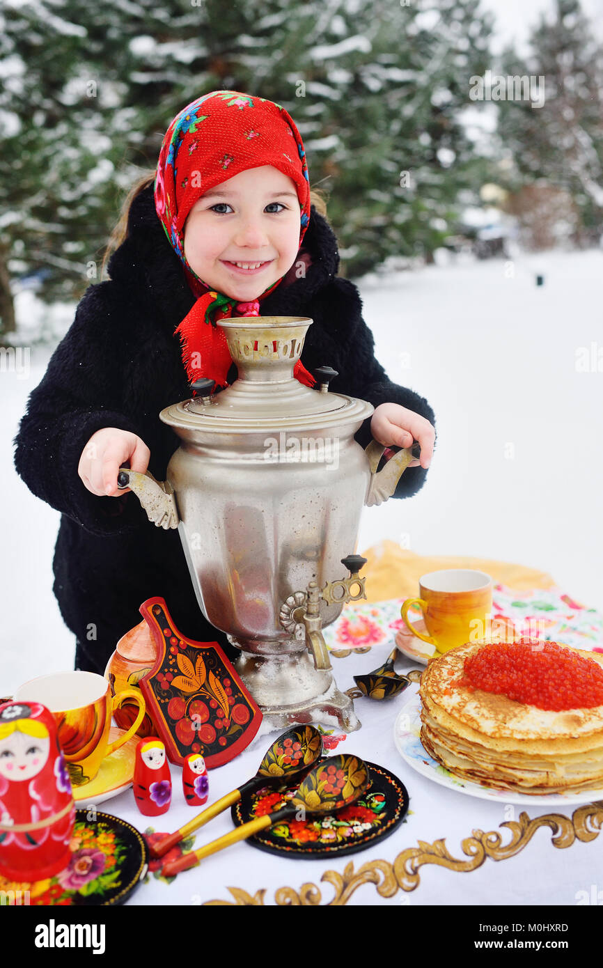 Enfant fille dans un manteau de fourrure et dans une écharpe en style russe  tenant un grand samovar dans les mains de crêpes avec du caviar rouge Photo  Stock - Alamy