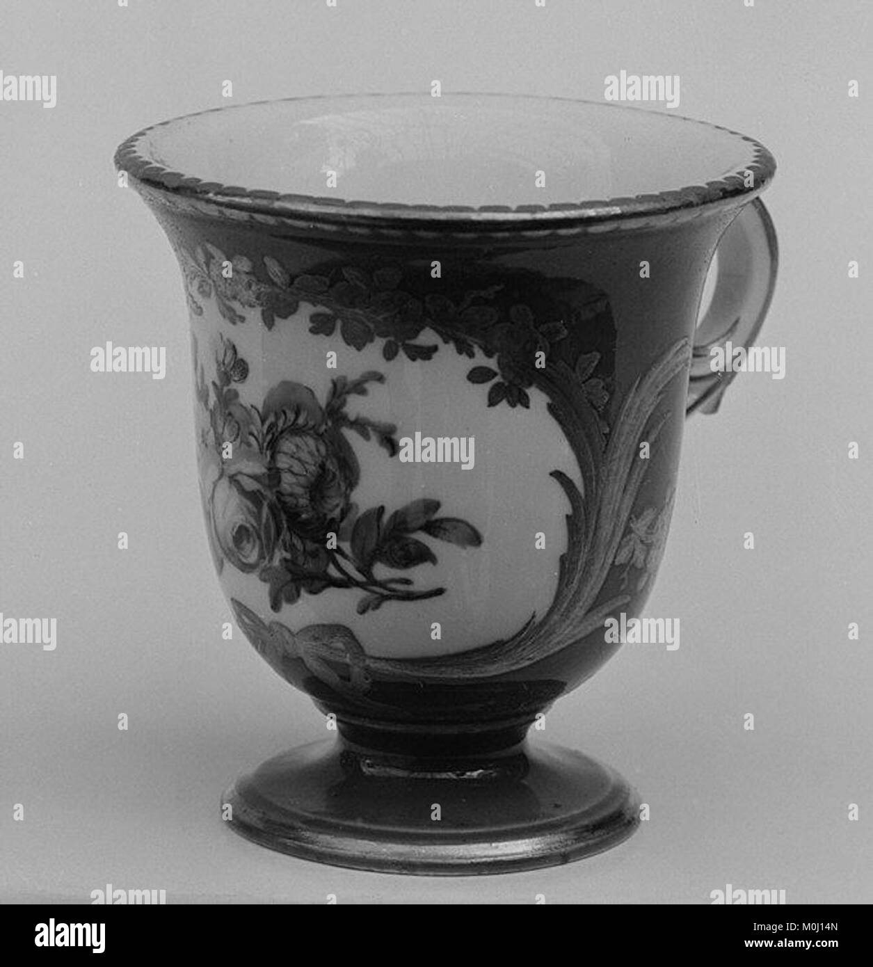 Cette tasse à crème glacée, qui fait partie d'un service de desserts de 31 pièces, présente une forme de porcelaine façonnée avec des motifs décoratifs peints et des garnitures dorées, caractéristique de la vaisselle en porcelaine européenne au 18ème ou 19ème siècle. Banque D'Images