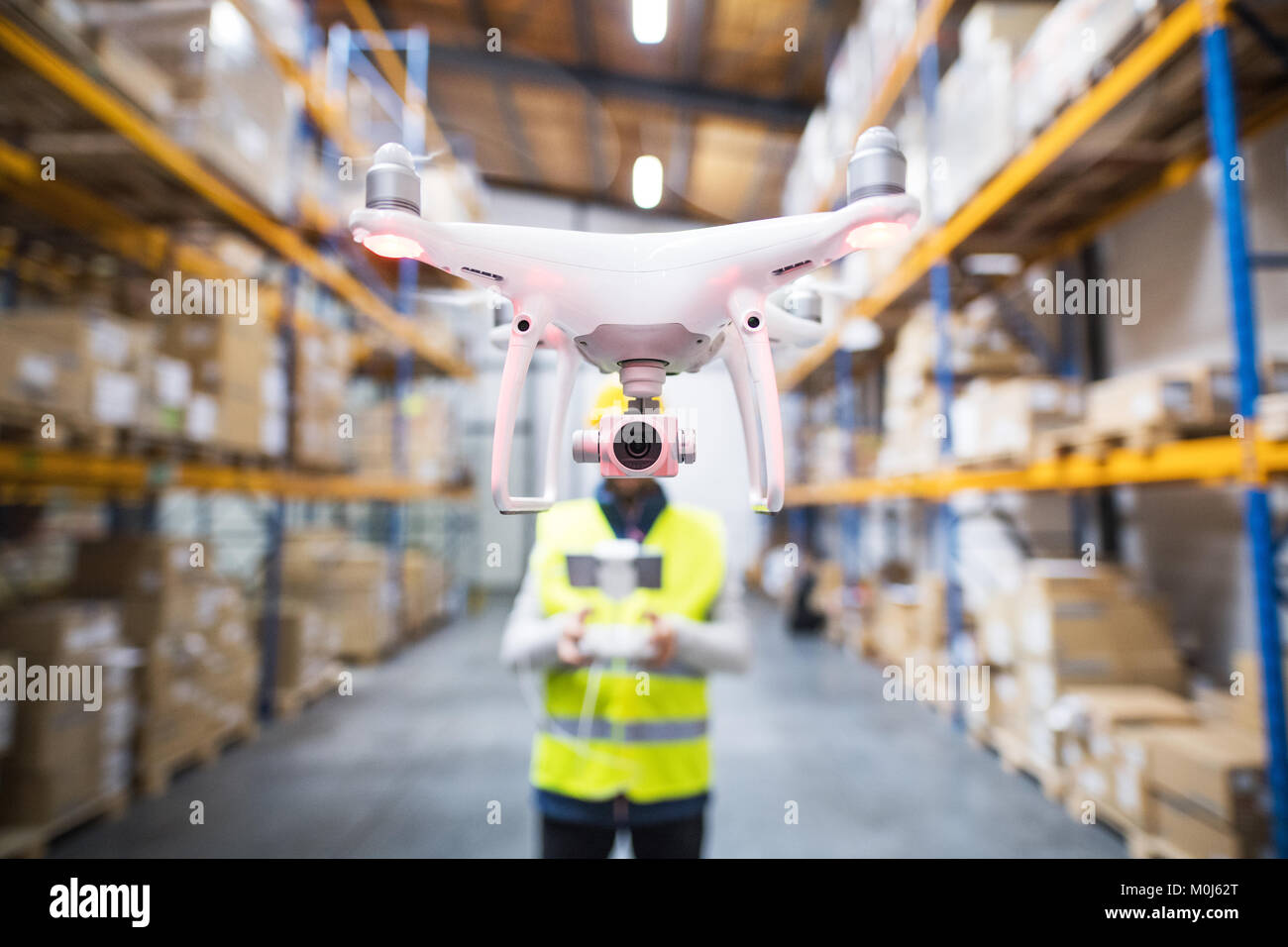Homme avec drone dans un entrepôt. Banque D'Images