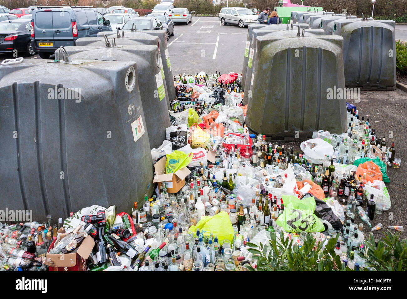 Verre plein et le débordement des bacs de recyclage dans le parc de voiture après Noël et Nouvel An Banque D'Images