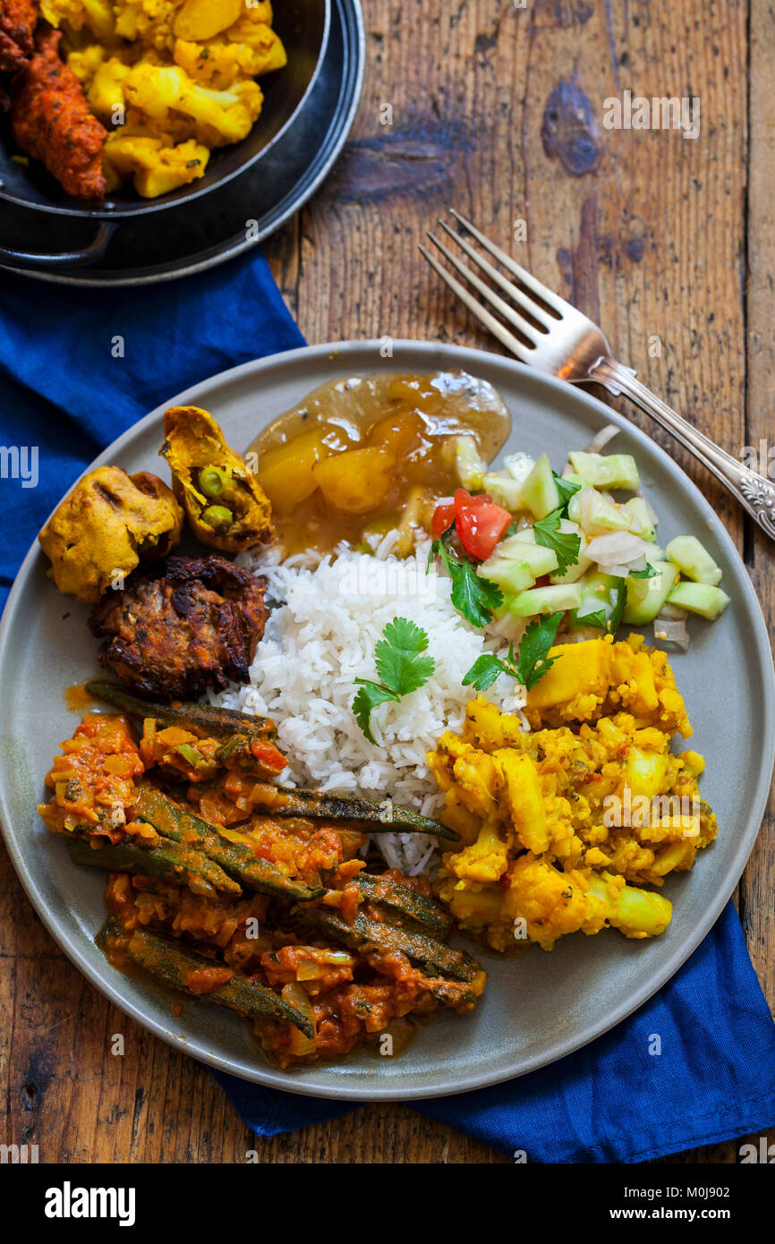 Repas indien avec Aloo Gobi, okra curry, riz et pakoras Banque D'Images