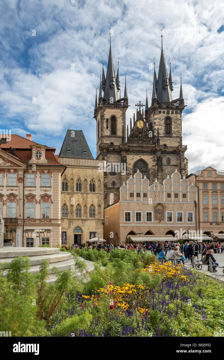 Un lit de fleurs autour d'une fontaine avec l'église de Notre-Dame de Týn une église gothique qui domine la place de la Vieille Ville à Prague, République Tchèque Banque D'Images