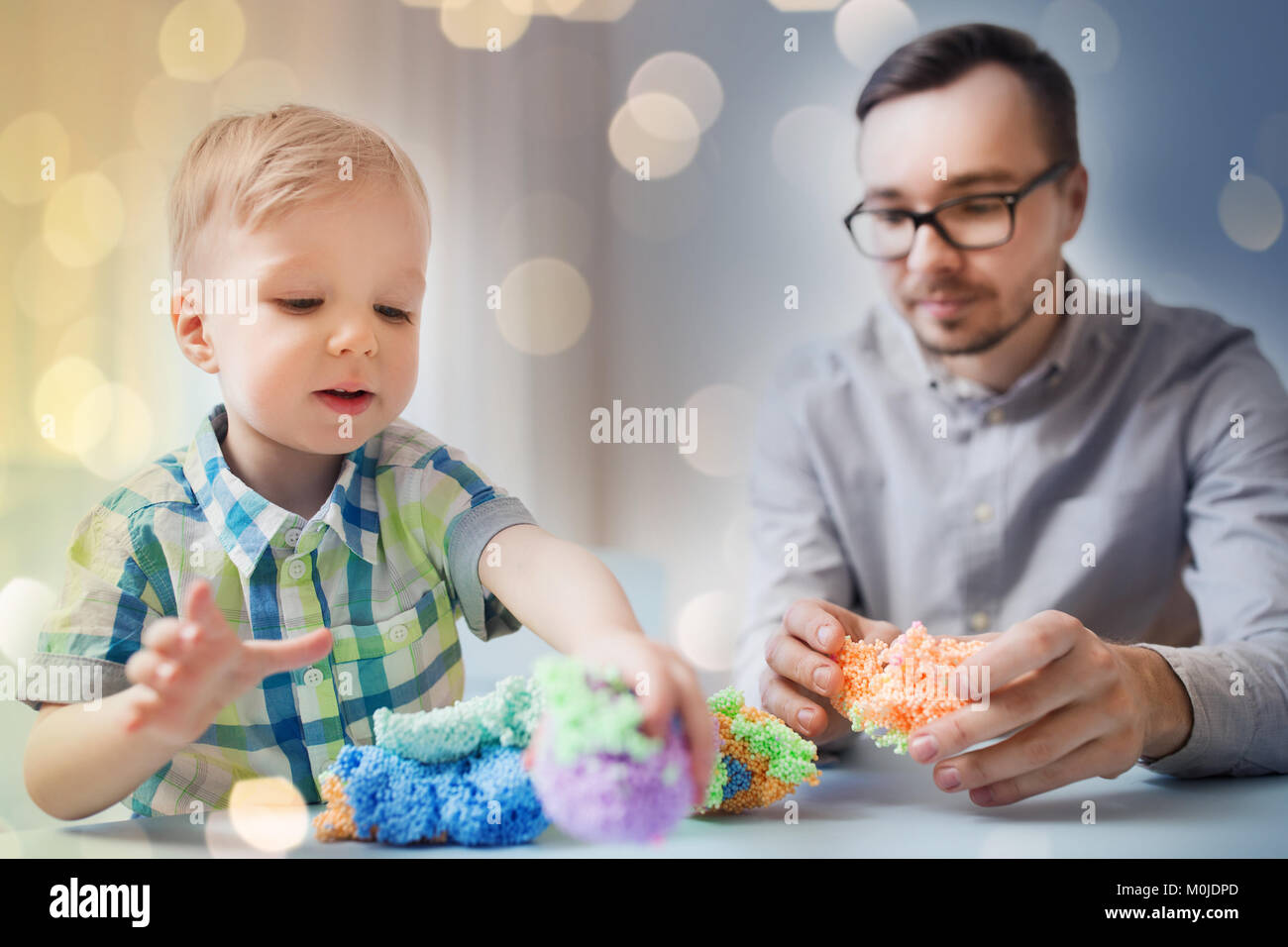 Père et fils Playing with ball clay à la maison Banque D'Images