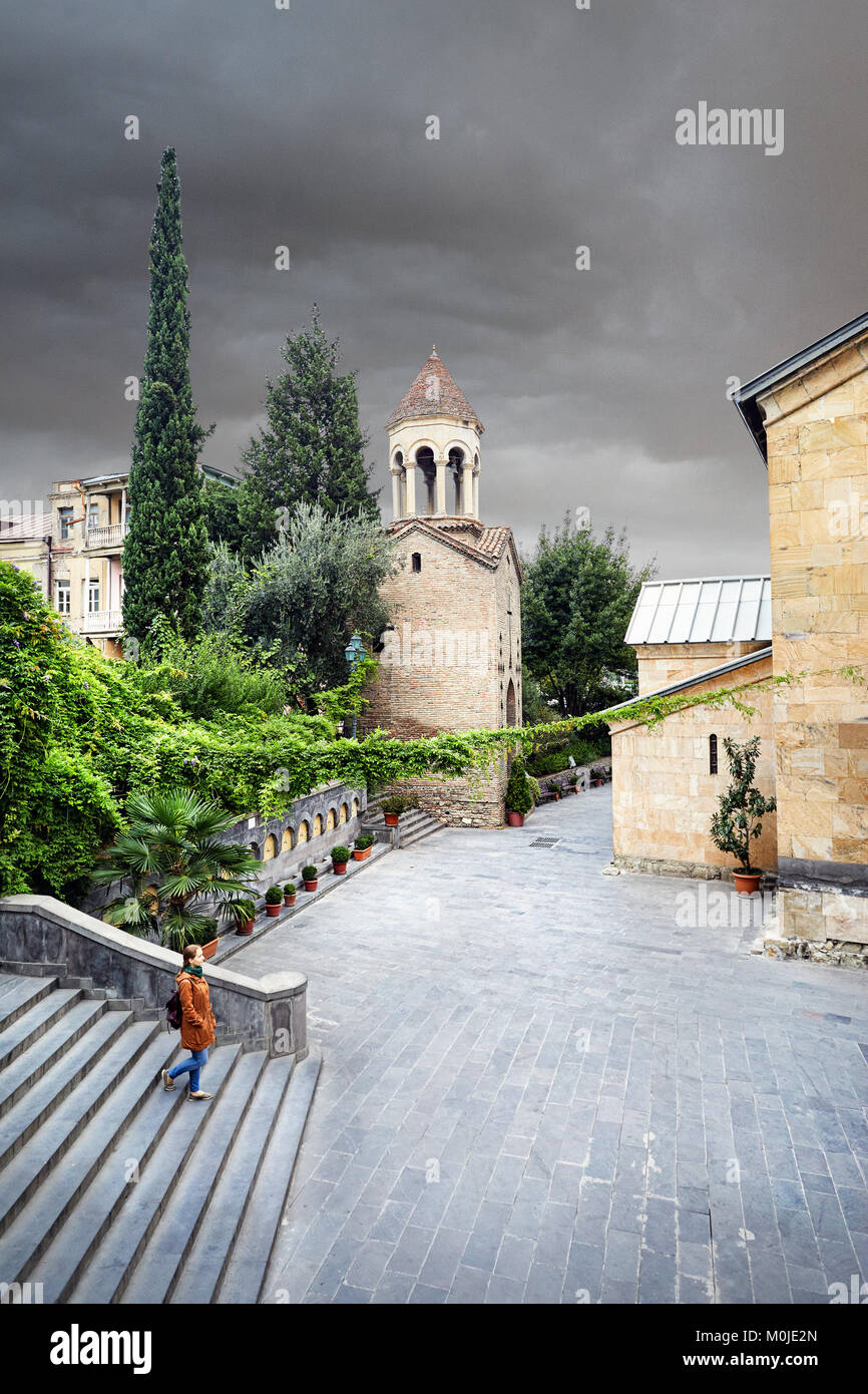 Femme veste marron en tourisme marche dans les vieilles rues près de Cathédrale Sioni dans le centre de Tbilissi, Géorgie Banque D'Images