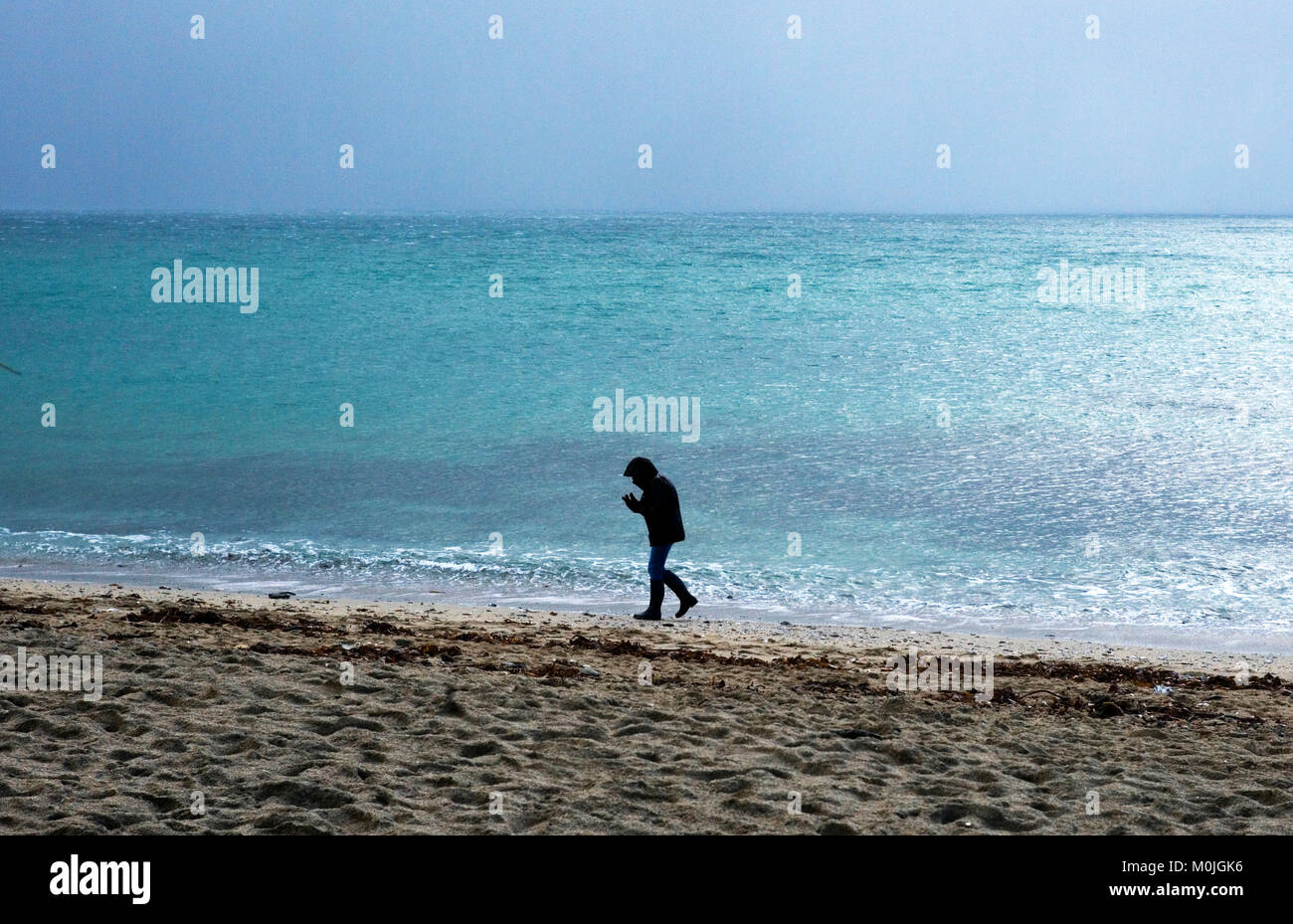 Un touriste se promène le long de la plage de Towan, près de Portscatho sur la péninsule de Roseland, à Cornwall, Angleterre, le 29 décembre 2017 Banque D'Images