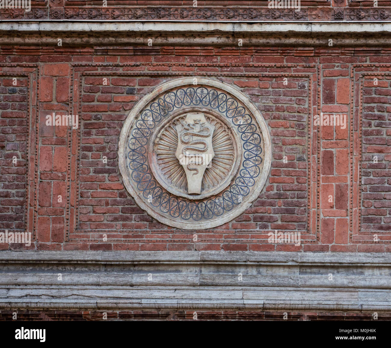 Le serpent, symboles de l'anciens seigneurs de Milan, sur le mur de brique rouge d'un bâtiment ancien Banque D'Images