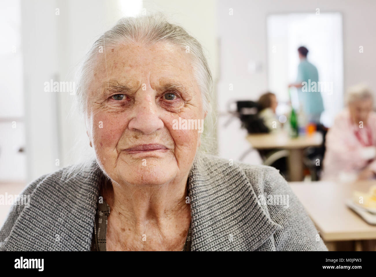 Les personnes âgées démentes dans une maison pour personnes âgées, flou à l'arrière du personnel infirmier, Allemagne Banque D'Images