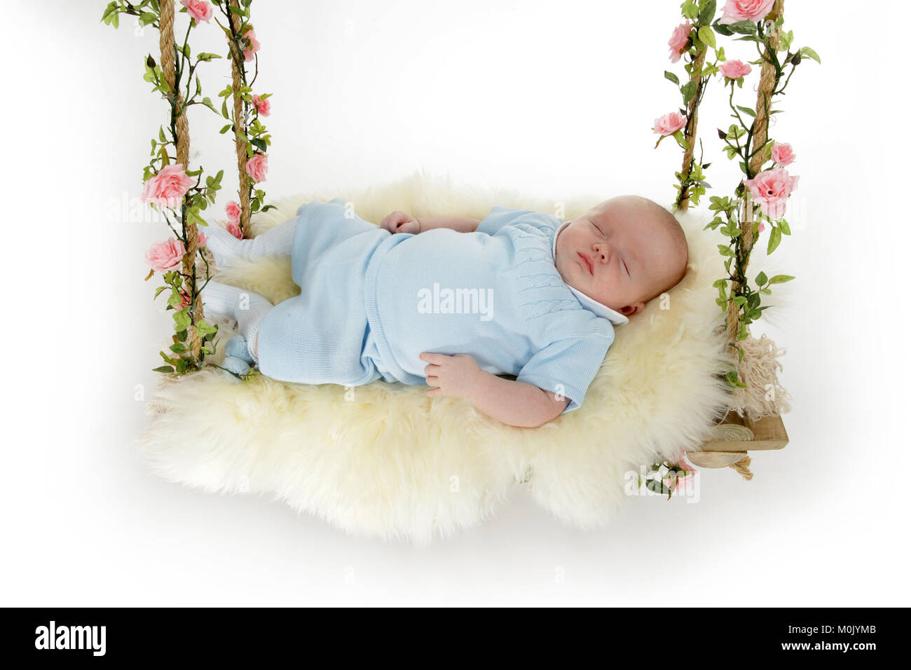 2 mois bébé garçon endormi sur swing rustique Banque D'Images