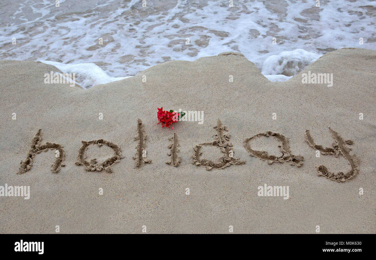 Maison de vacances le mot écrit sur le sable de l'océan Banque D'Images
