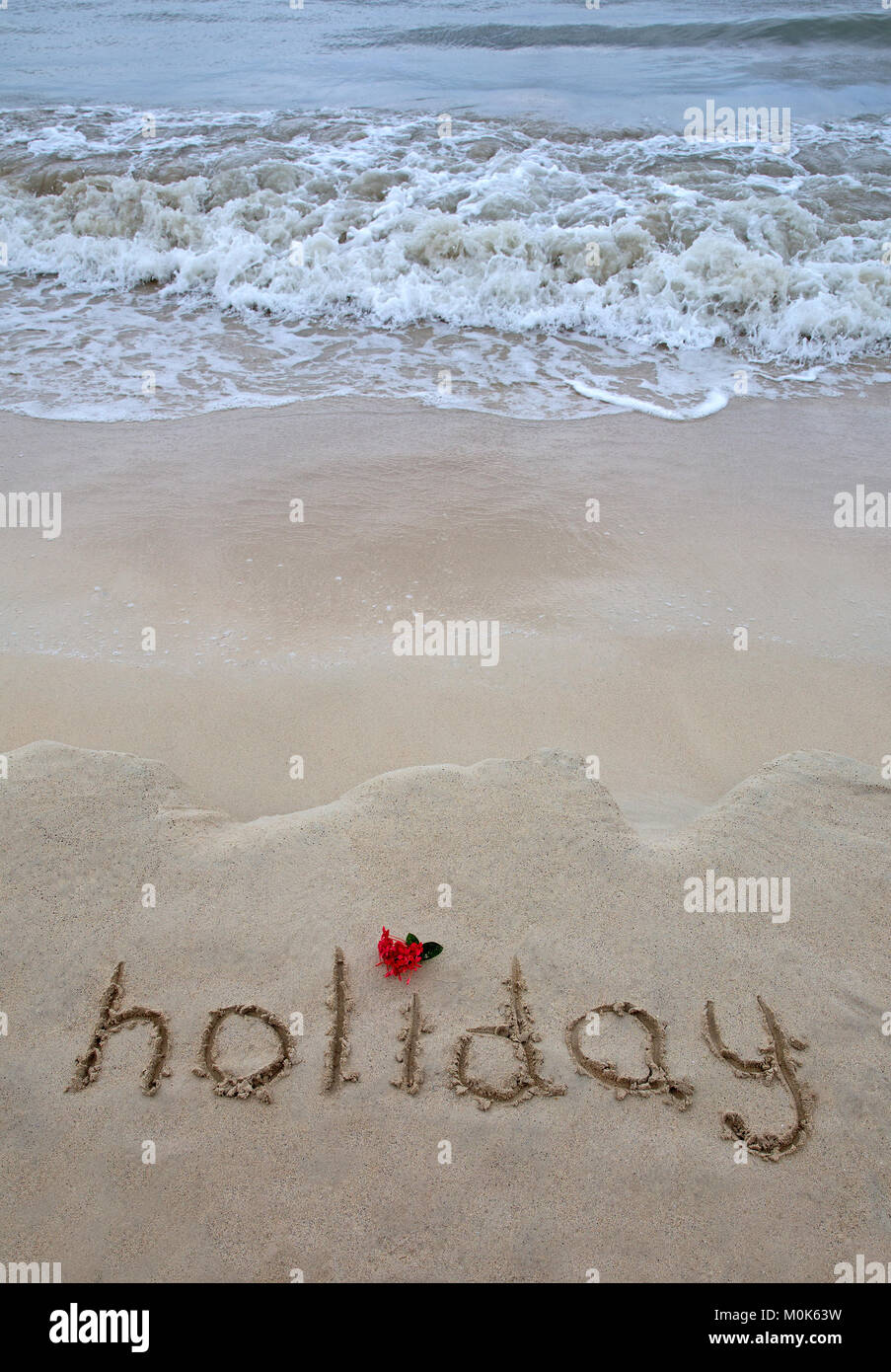 Maison de vacances le mot écrit sur le sable de l'océan Banque D'Images